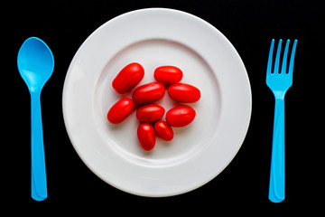 fresh tomato on plate with spoon on black background