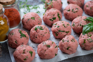 Close-up of raw fresh meatballs on a baking paper ready to be cooked, selective focus