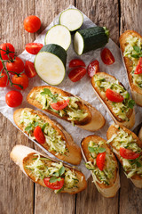 Italian bruschetta with zucchini and tomatoes close-up and ingredients. Vertical top view