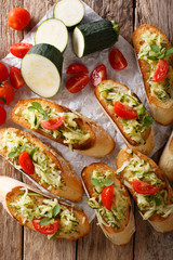 Bruschetta with grated zucchini and tomatoes close-up and ingredients. Vertical top view
