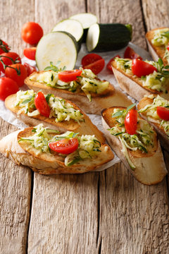 Bruschetta with grated zucchini and tomatoes close-up and ingredients. vertical