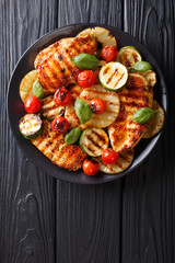 Chicken fillet grilled with vegetables in a sweet-hot sauce close-up. Vertical top view