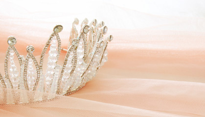Vintage tulle pink chiffon dress and diamond tiara on wooden white table. Wedding and girl's party concept © tomertu