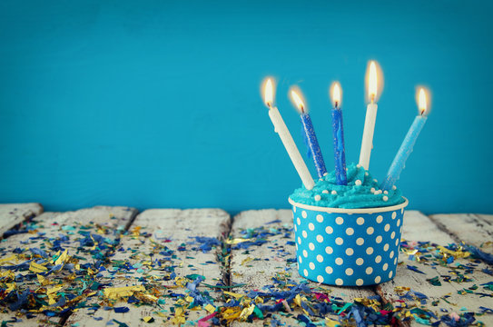 Birthday concept with cupcake and candles on wooden table