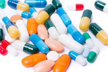 colored pills and capsule on white background
