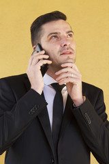 Man with suit thinking and talking with cellphone