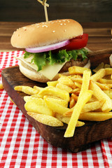 fresh tasty burger and french fries on wooden table
