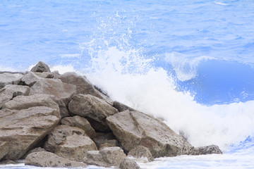 Sea wave to the beach with stone wall.