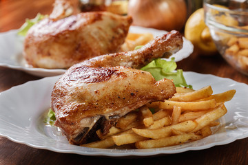 Roasted chicken legs with french fries and lettuce