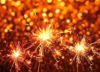 sparkler fire on red bokeh abstract. Christmas background.
