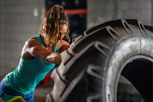 Woman athlete exercising with tire