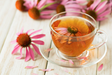 Cup of echinacea tea on white wooden table
