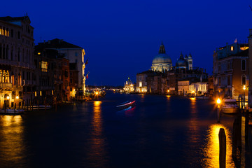 Fototapeta na wymiar Venice night cityscape at grand canal with buildings and famous church, long exposure