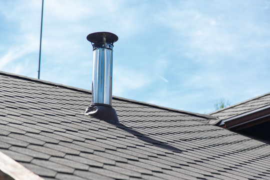 Chimney Pipe From Stainless Steel On The Roof Of The House.