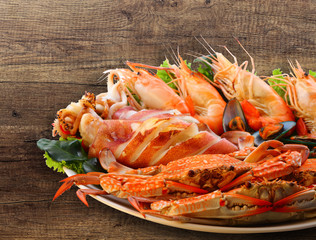 Mixed seafood grill and salad leaves on wooden