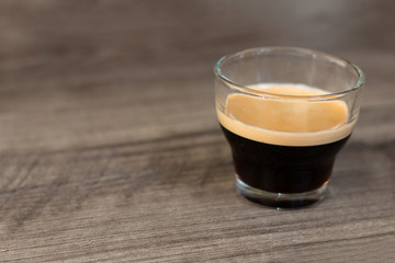 Espresso glass cup on top of a wooden table