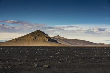 Brown isolated mountain with black volcanic ashes field and blue sky in summer, Landmannalaugar,...