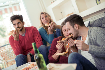 Young people resting with pizza and drinks