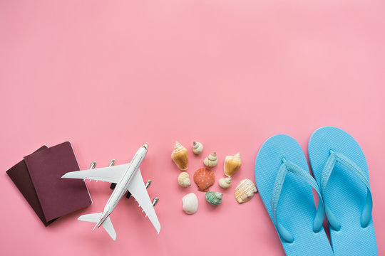 Flat lay design of travel concept with blue sandal ,plane, passport and shells on pink pastel background with copy space.
