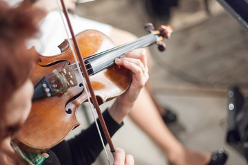 performance, music, orchestra concept. the most elegant musical instrument, violin, in tender hands of musician. it has four strings and gorgeous form of young woman