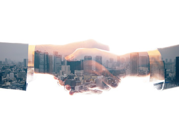 double exposure of shaking hands and urban skyline. abstract mixed media.