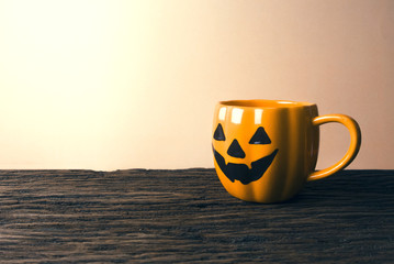 halloween pumpkin coffee cup on wood table