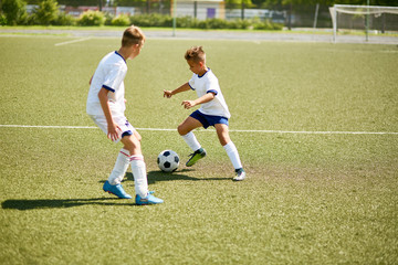 Obraz premium Boys Playing Football on Field