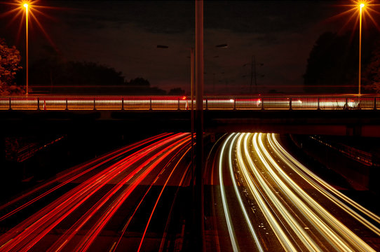 Red and white light trails left by night time traffic. 
