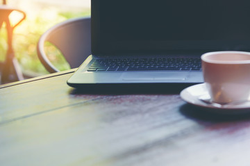 Business concept : Laptop for working on wood background with a cup of coffee foreground
