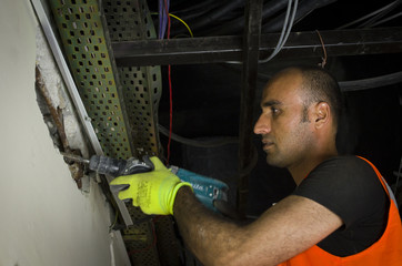 Fototapeta premium Man using a jackhammer to drill into wall