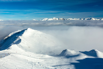 View of Ski Piste down to valley covered by cloud layer