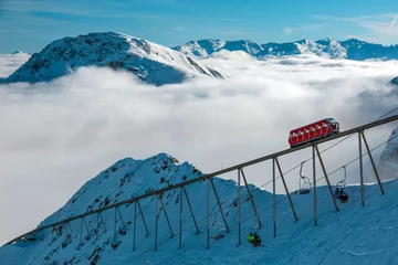 Foto op Plexiglas Uitzicht op alpine Ski Resort Mountain Ridge Wolken en Lift © alexbrylovhk