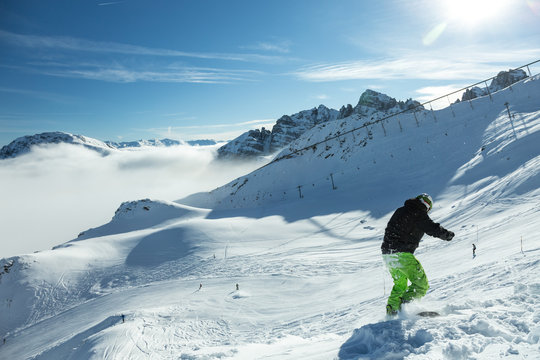 Brave Snowboarder starting his Ride on Mountain Piste