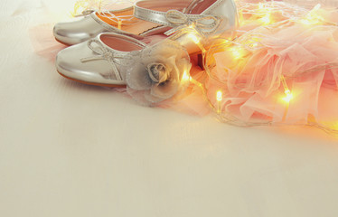 Vintage tulle pink chiffon dress and silver shoes on wooden white floor