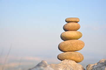 Fototapeta na wymiar Balanced stone pyramid on mountain. Zen rock, concept of balance and harmony