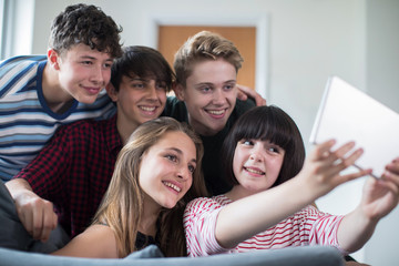 Obraz premium Group Of Teenage Friends Posing For Selfie On Digital Tablet