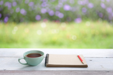 Red tea cup and notebook at outdoor