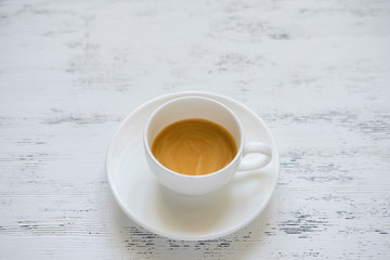 Cup of black coffee on the white table