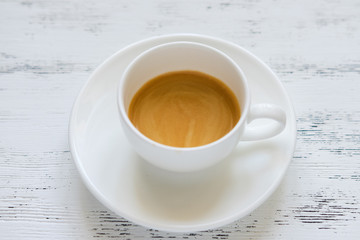 Cup of black coffee on the white table