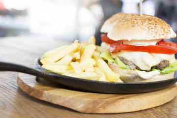 Delicious burgers with beef, tomato, cheese, and lettuce. Beautiful and tasty meal at the restaurant.