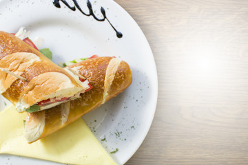 Club sandwich with chicken breast, bacon, tomato, cucumber, and herbs. French fries on the side.