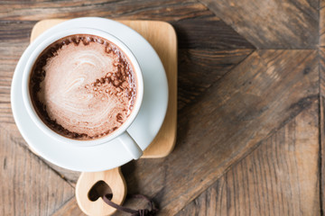 heart shape art on hot chocolate drink in white mug on wood table