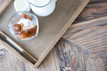 heart shape frozen coffee ice cubes and vanilla ice cream with milk jar on wood table