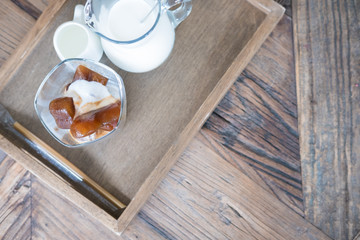 heart shape frozen coffee ice cubes and vanilla ice cream with milk jar on wood table