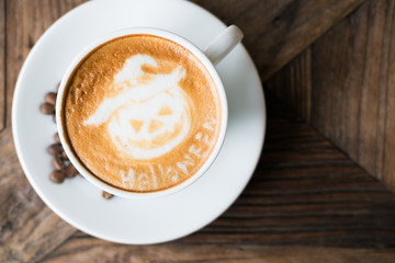 halloween latte art on hot cappuccino coffee in white mug on wood table