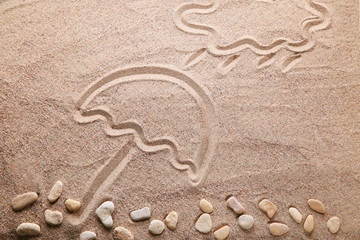 Fototapeta na wymiar Cloud and umbrella drawn on the beach sand