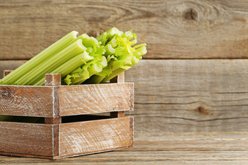 Celery in crate on grey wooden table