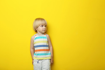 Portrait of little boy on yellow background