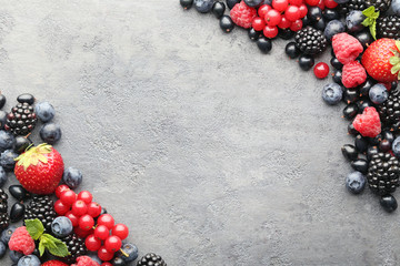 Ripe and sweet berries on grey wooden table