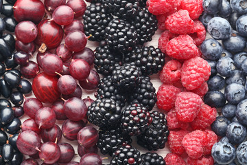 Ripe and sweet berries on white wooden table